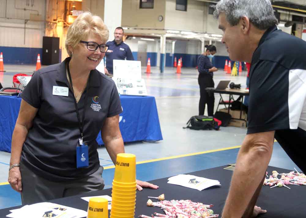 Click to enlarge,  Central Carolina Community College President Dr. Lisa M. Chapman visits with one of the exhibitors at the CCCC Manufacturing Day event. 