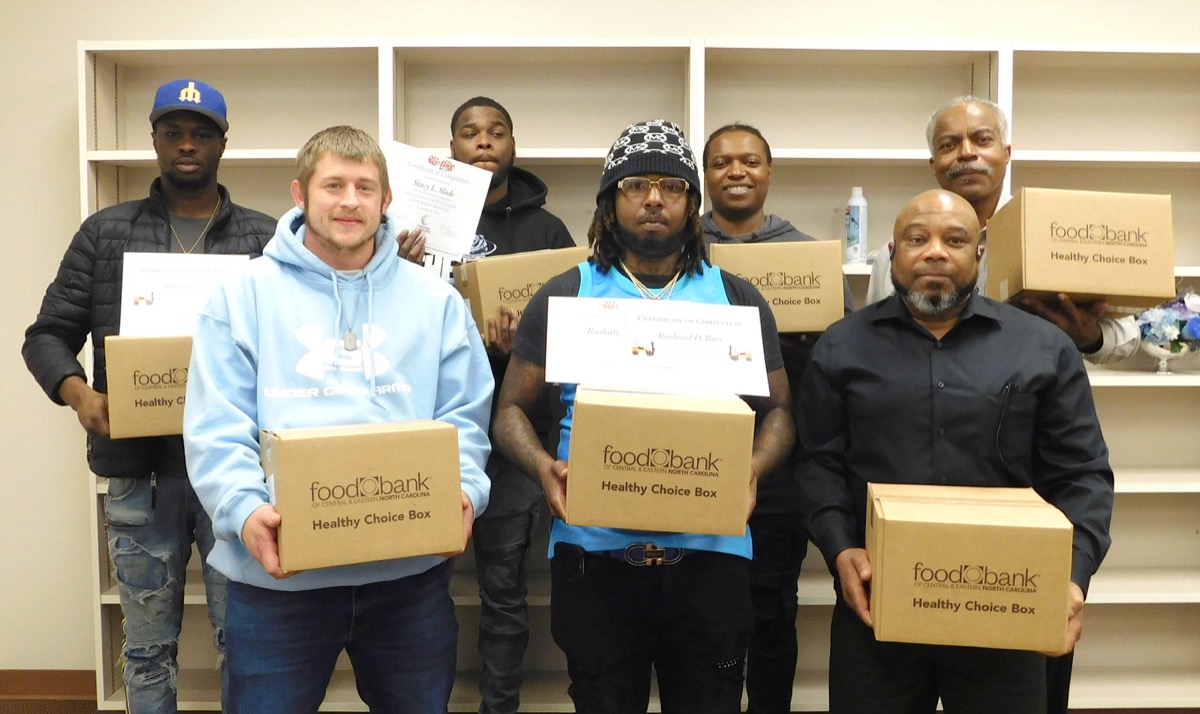 Click to enlarge,  Members of the first Forklift Fundamentals and Job Readiness Boot Camp at Central Carolina Community College receive food boxes from the Food Bank of Central and Eastern North Carolina. 