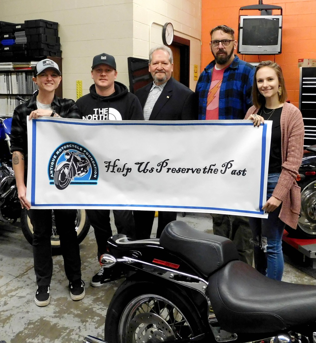 Click to enlarge,  John Fiorino (center), Treasurer of The Antique Motorcycle Foundation, recently visited Central Carolina Community College to get a first-hand look at the CCCC Motorcycle Mechanics program and to present the scholarships to the four students. Scholarship recipients pictured with Mr. Fiorino, are, left to right: Stacey Suit, Michael Regenhardt, Robert Clayton, and Sierra Rathbun. 
