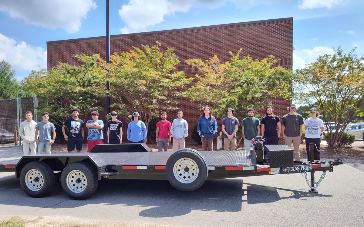 Click to enlarge,  Central Carolina Community College Automotive Restoration students stand by the heavy duty trailer donated by American television host, writer and comedian Jay Leno and Texas Pride Trailers. 