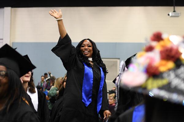 Excited graduate waving to her family and friends